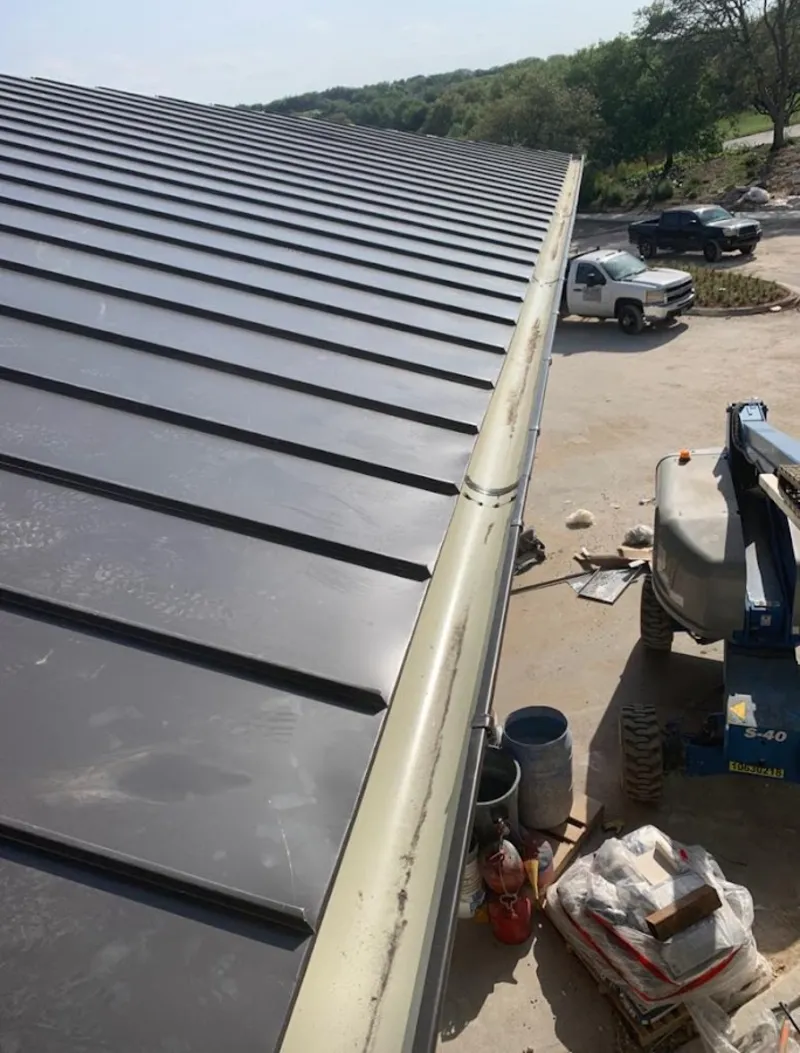 Standing seam panel and gutter detail on a metal roofing jobsite in Queensbury